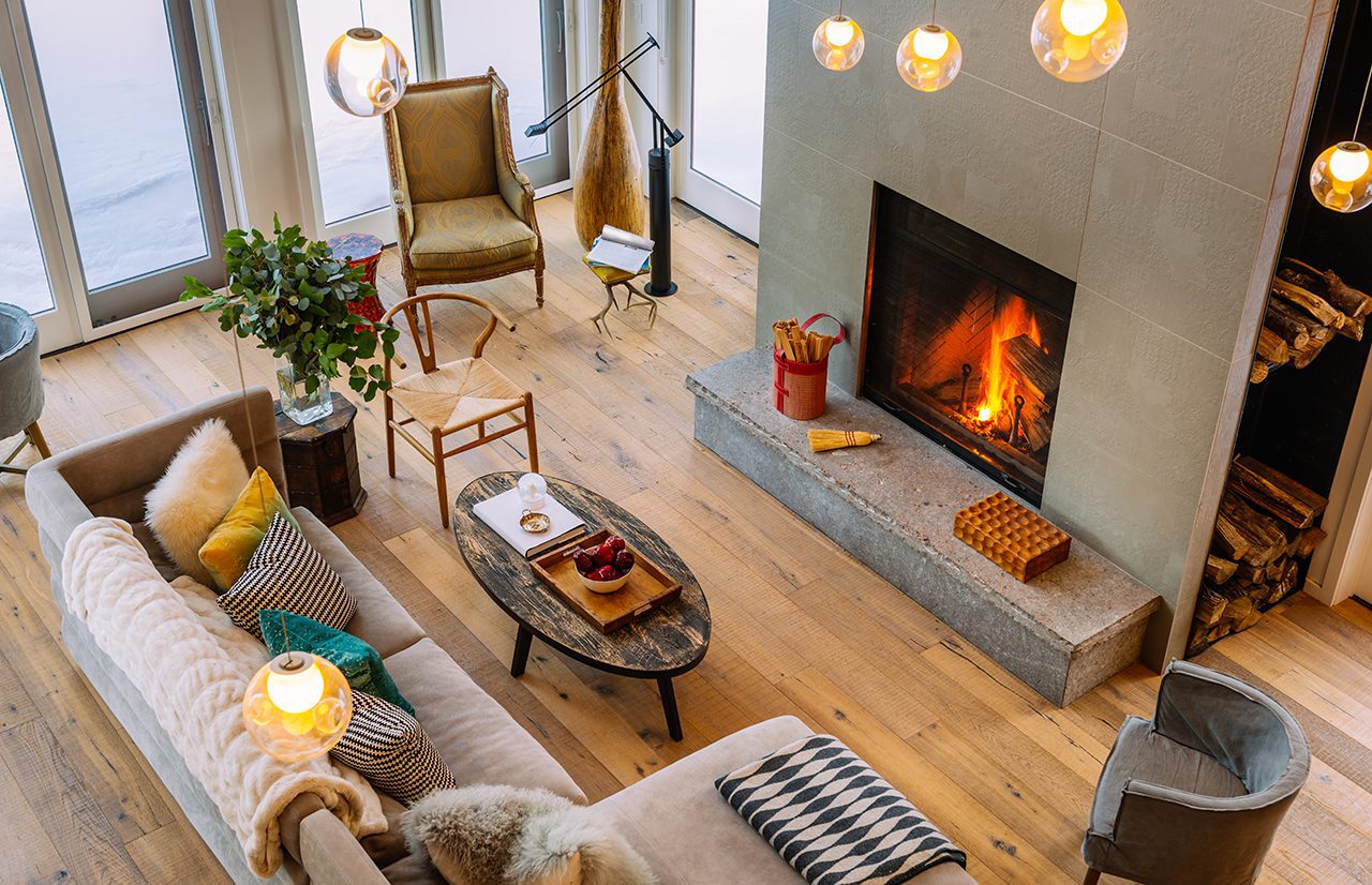Wood burning fireplace in a living room with winter outside.